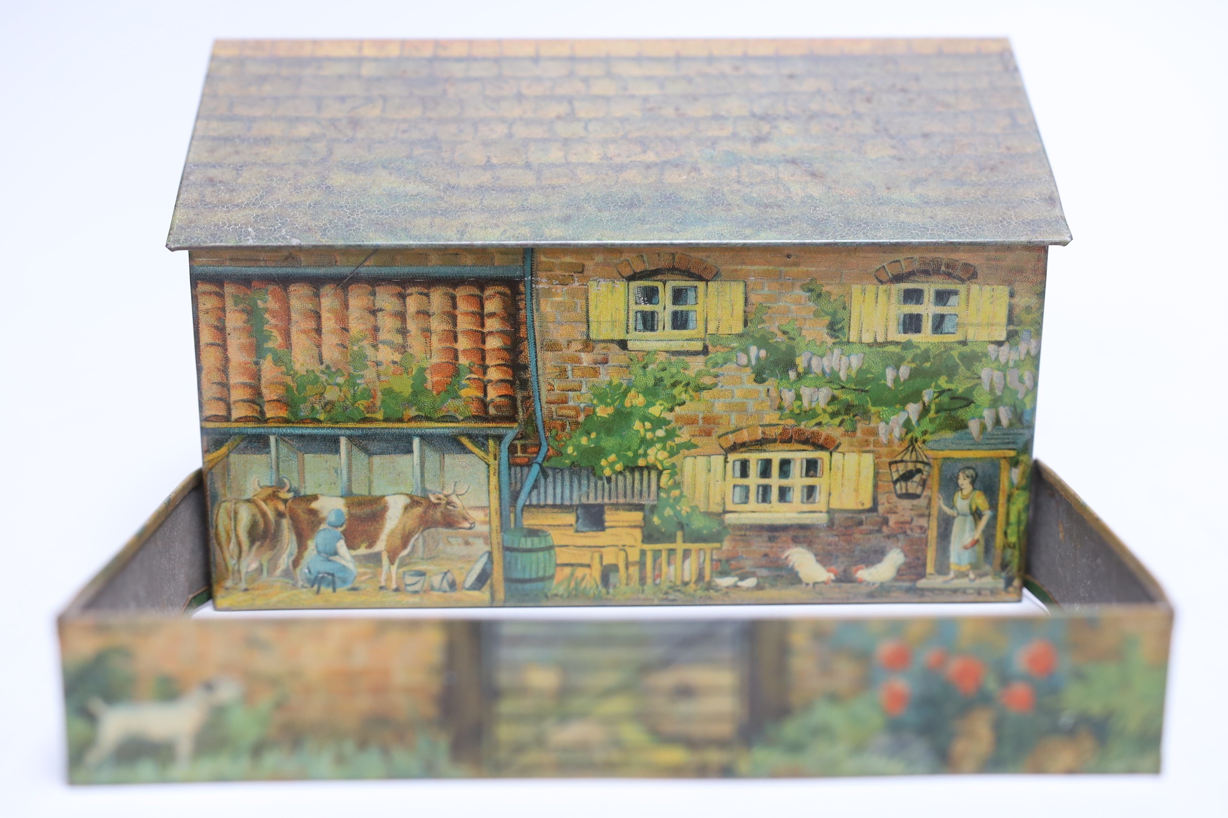 Britains farm series, a Schuco type monkey and a Huntley & Palmers novelty farmhouse biscuit tin, 16cm wide
